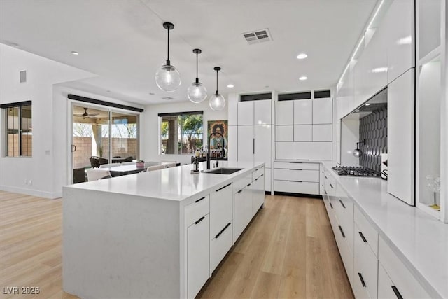 kitchen featuring a sink, visible vents, white cabinetry, and modern cabinets
