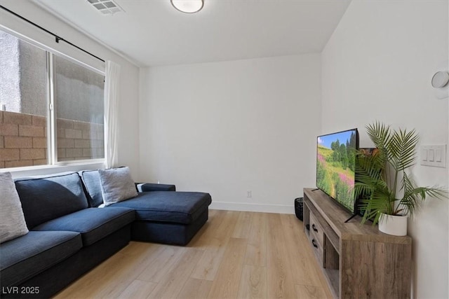 living area with visible vents, light wood-style flooring, and baseboards