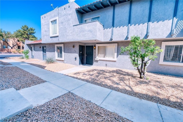 view of front of house featuring a tiled roof and stucco siding
