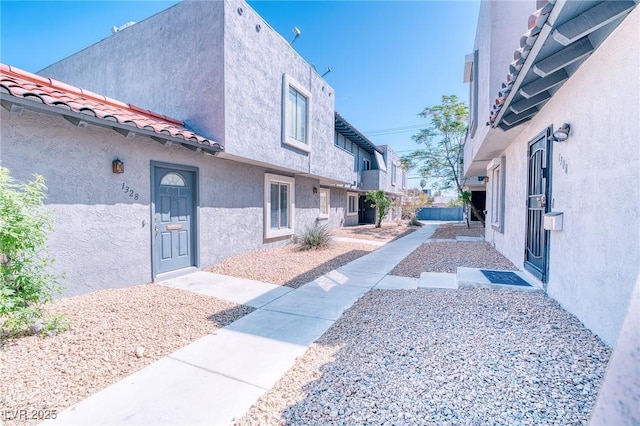 exterior space with stucco siding and a tiled roof