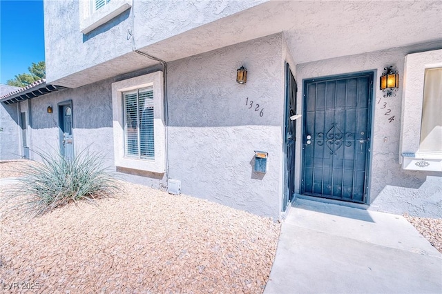 property entrance with stucco siding
