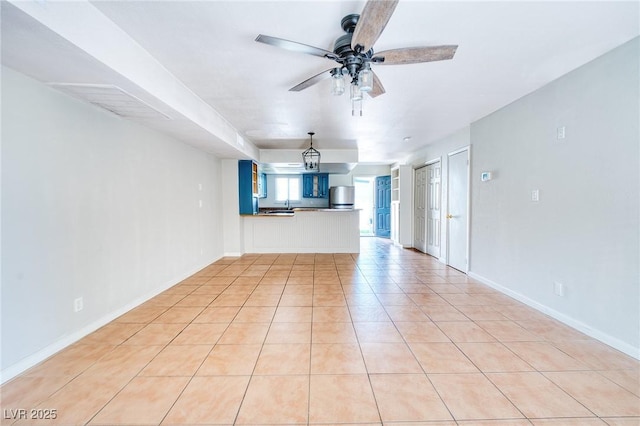 unfurnished living room with light tile patterned floors, baseboards, and a ceiling fan