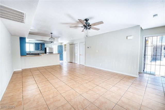 unfurnished living room featuring light tile patterned flooring, ceiling fan, baseboards, and visible vents