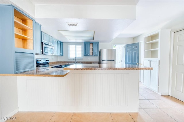 kitchen featuring open shelves, a sink, a peninsula, stainless steel appliances, and blue cabinets