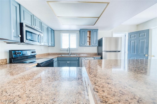 kitchen with appliances with stainless steel finishes, a sink, and blue cabinetry