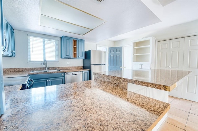 kitchen featuring light tile patterned floors, open shelves, a sink, appliances with stainless steel finishes, and blue cabinets
