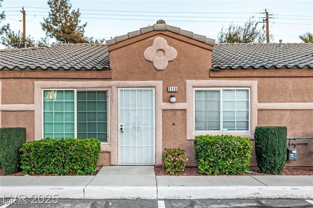 view of front of home with a tiled roof and stucco siding