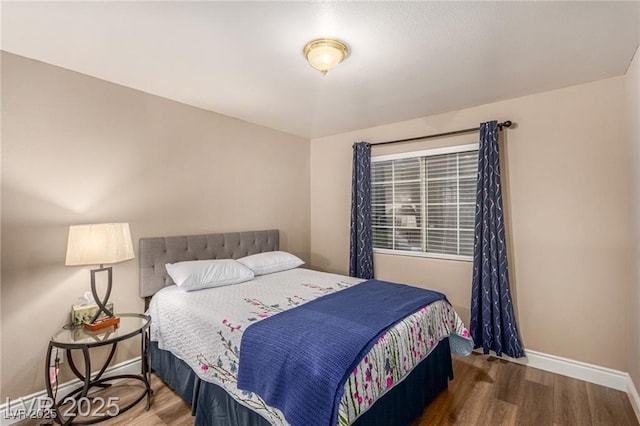 bedroom with baseboards and wood finished floors