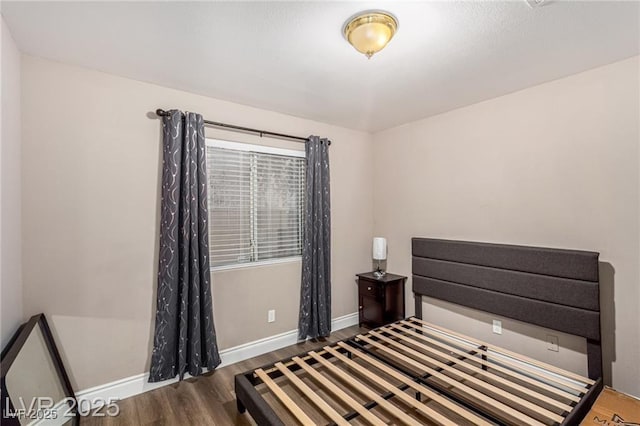 bedroom featuring baseboards and wood finished floors