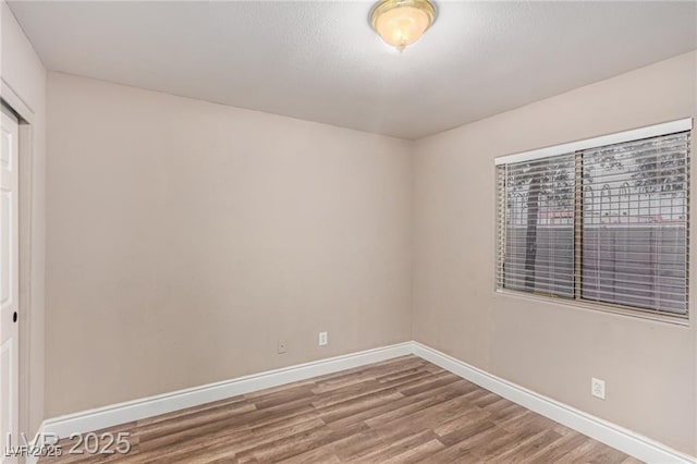 unfurnished room featuring wood finished floors and baseboards