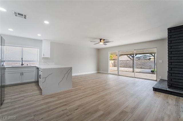 living room featuring light wood-style floors, ceiling fan, visible vents, recessed lighting, and baseboards