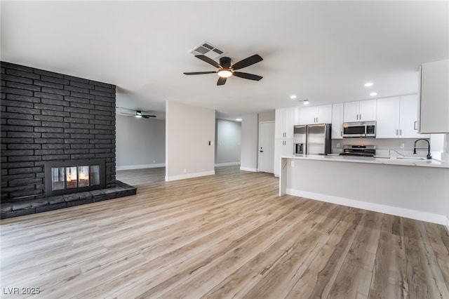 kitchen with visible vents, open floor plan, light countertops, appliances with stainless steel finishes, and a peninsula