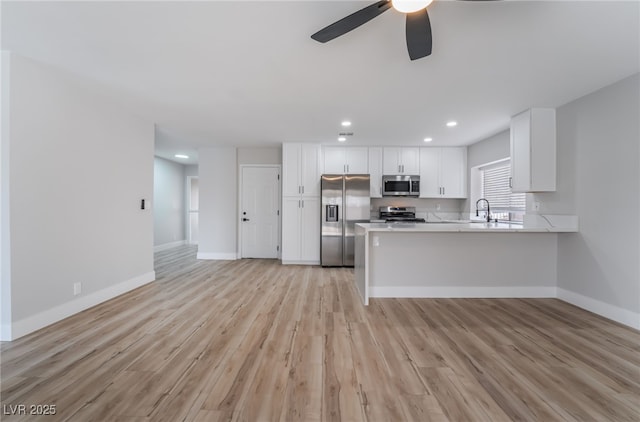 kitchen with white cabinetry, appliances with stainless steel finishes, baseboards, and a ceiling fan