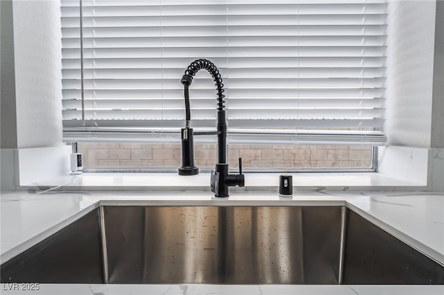 room details with light countertops, a sink, and backsplash