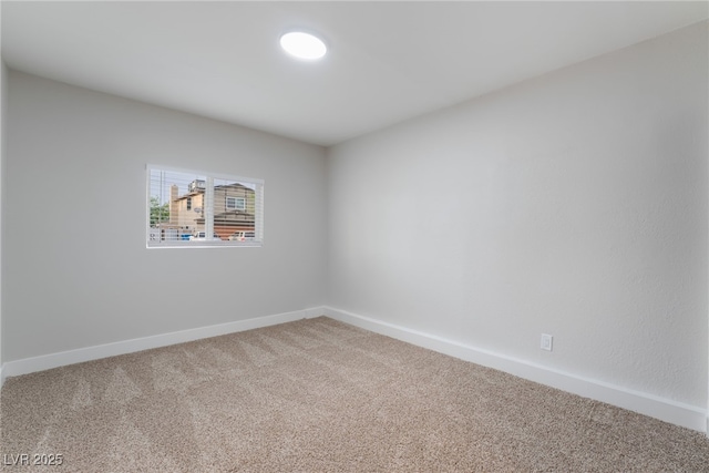 carpeted spare room featuring baseboards