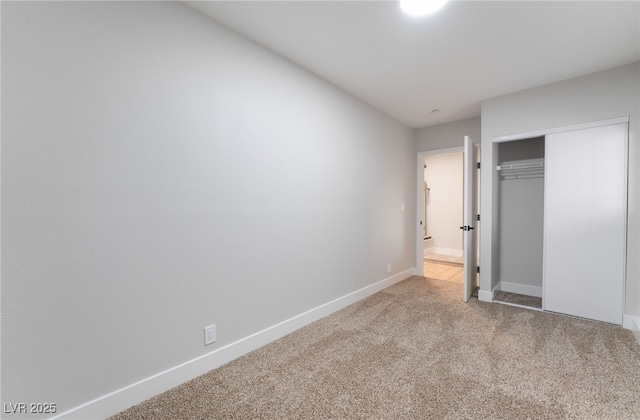 unfurnished bedroom with a closet, carpet flooring, and baseboards