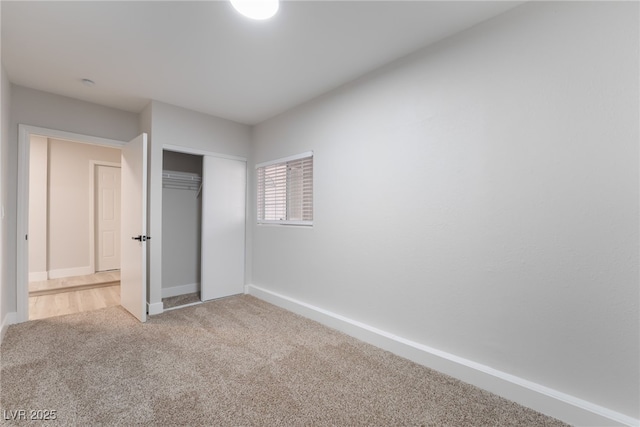 unfurnished bedroom featuring a closet, baseboards, and carpet