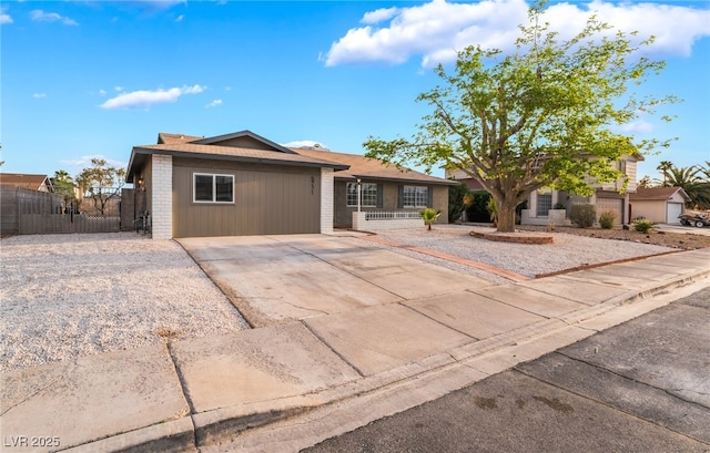 ranch-style house featuring brick siding, driveway, fence, and a gate