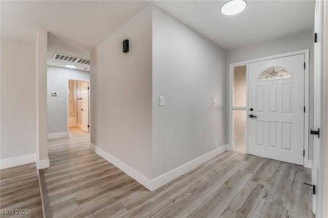 foyer entrance featuring light wood-style floors, baseboards, and visible vents