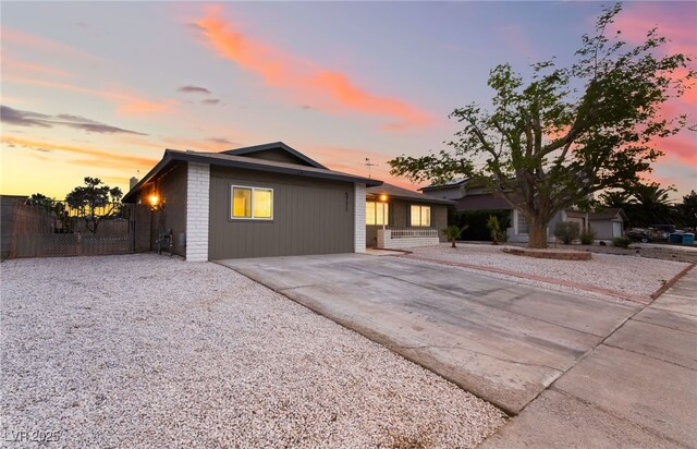 ranch-style house featuring concrete driveway and fence
