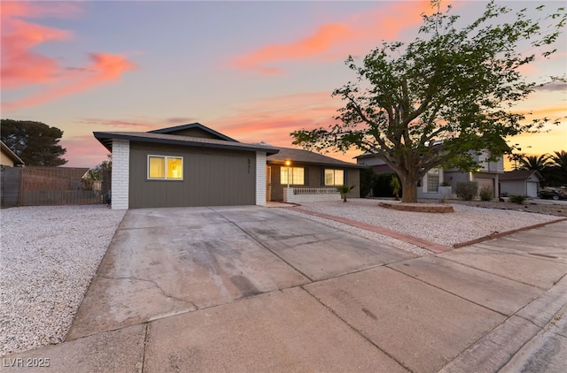 view of front of property with fence and concrete driveway