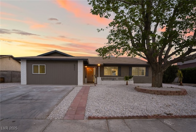 ranch-style house with brick siding, driveway, and fence