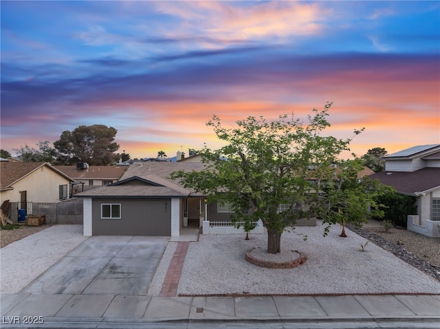 ranch-style home with concrete driveway, fence, and a garage