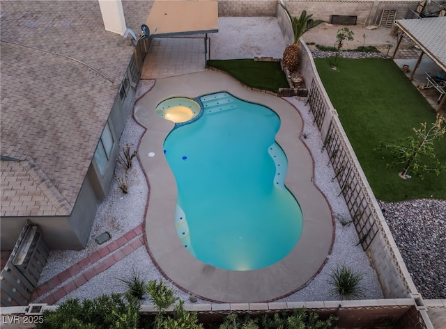 view of swimming pool featuring a fenced backyard, a pool with connected hot tub, and a patio area