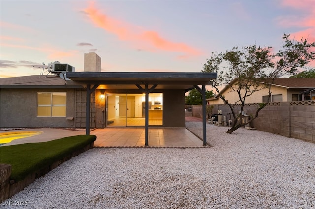 rear view of property featuring a patio area, fence, central AC, and a chimney