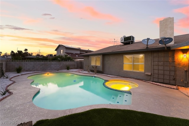 view of swimming pool with a patio area, a fenced backyard, central AC unit, and a pool with connected hot tub