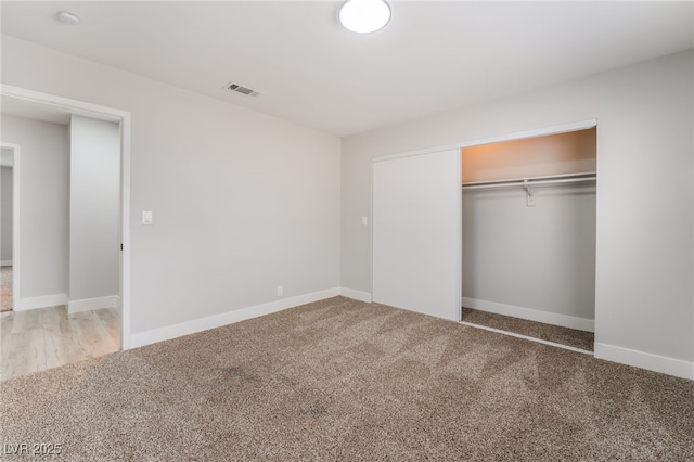 unfurnished bedroom with visible vents, a closet, baseboards, and carpet floors