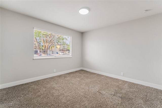 unfurnished room featuring baseboards and carpet