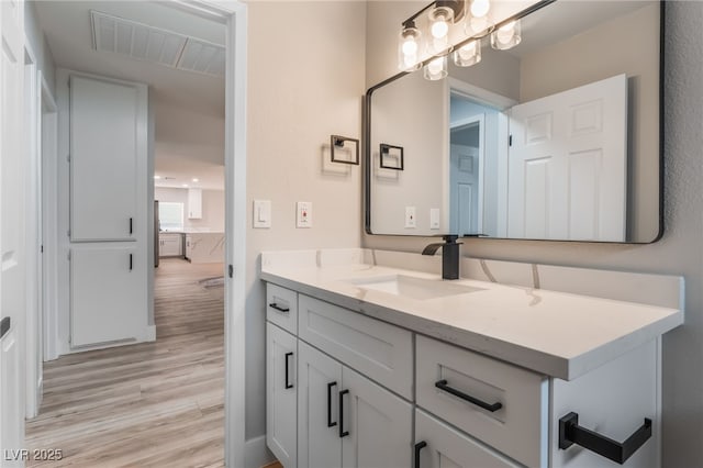 bathroom featuring visible vents, vanity, and wood finished floors