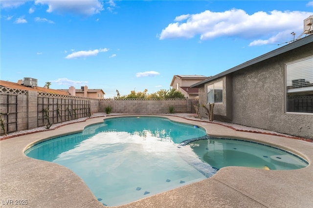 view of pool featuring a fenced backyard and a pool with connected hot tub