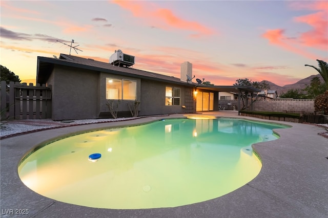 pool at dusk featuring a fenced in pool, a patio, and fence