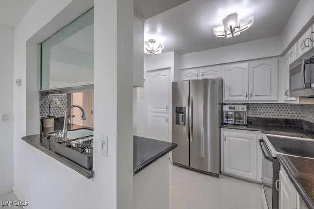 205 E Harmon Ave Unit 803, Las Vegas, NV 89169 - kitchen with appliances with stainless steel finishes, backsplash, white cabinetry, and light tile patterned floors