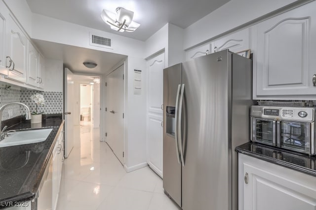 205 E Harmon Ave Unit 803, Las Vegas, NV 89169 - kitchen featuring stainless steel fridge with ice dispenser, dark stone counters, tasteful backsplash, white cabinetry, and light tile patterned floors