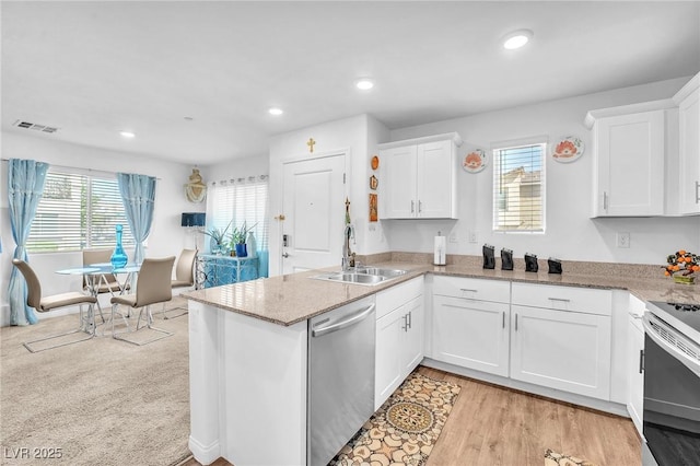 kitchen featuring a sink, white cabinets, stainless steel dishwasher, and a peninsula