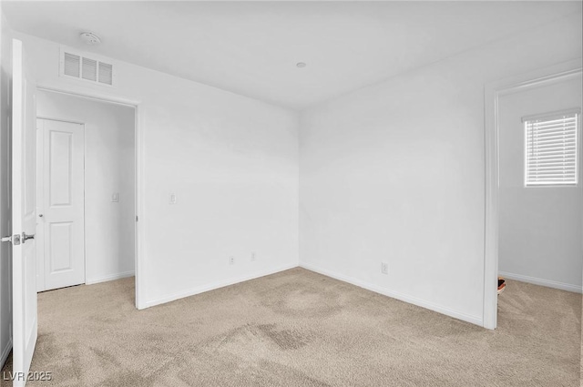 empty room featuring visible vents, baseboards, and carpet floors