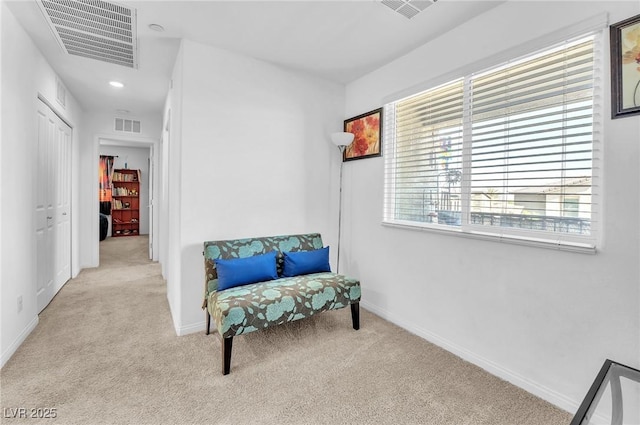 living area with carpet floors, baseboards, and visible vents