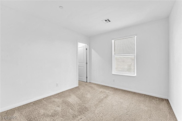 carpeted spare room featuring visible vents and baseboards