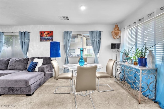 carpeted dining area with a healthy amount of sunlight and visible vents