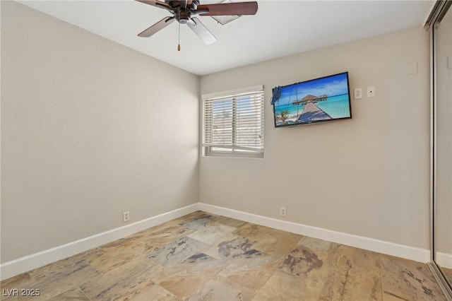 spare room with baseboards and a ceiling fan