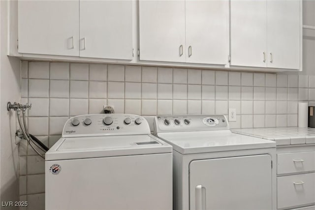 laundry area featuring washing machine and dryer and cabinet space