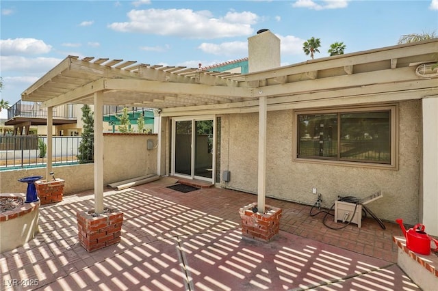 rear view of property with a patio, a chimney, a pergola, and stucco siding