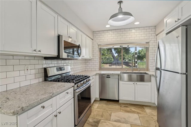 kitchen featuring stainless steel appliances, white cabinets, and a sink