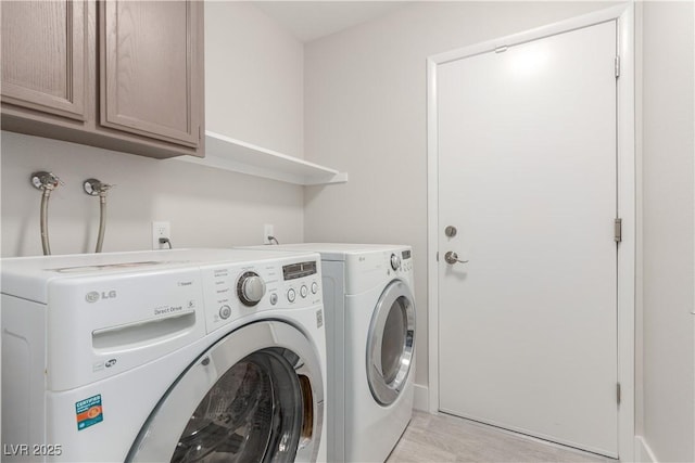 washroom featuring separate washer and dryer and cabinet space