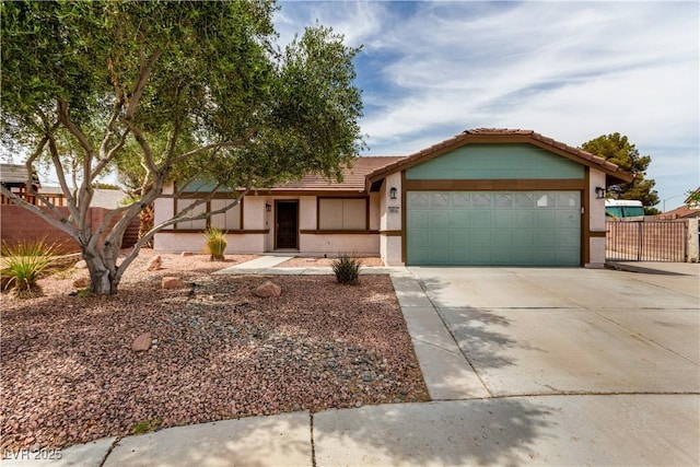 view of front of home featuring stucco siding, fence, a tile roof, a garage, and driveway