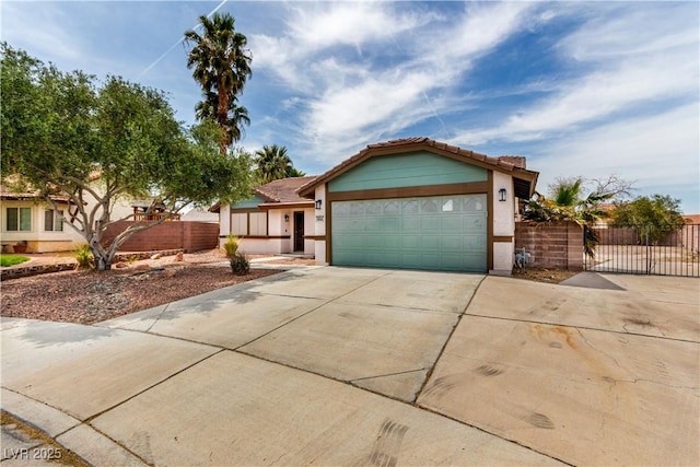 view of front facade featuring concrete driveway, a garage, fence, and a tile roof