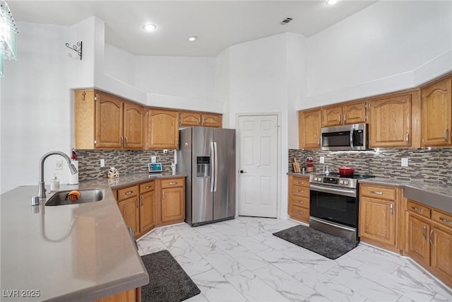 182 Horizon View Dr, Henderson, NV 89015 - kitchen featuring a sink, stainless steel appliances, marble finish floor, and brown cabinets